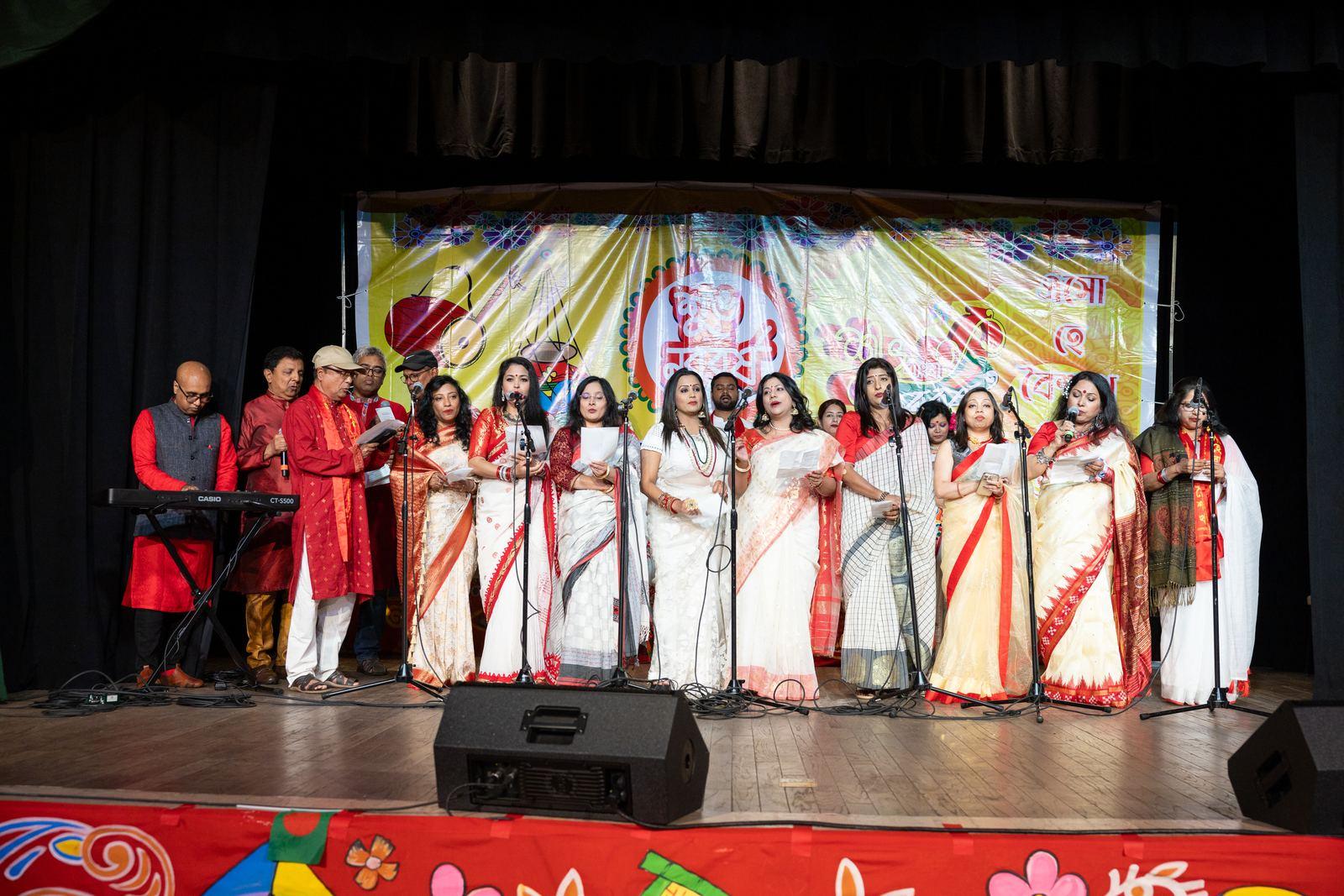 Adult performers in colorful sarees and formalwear on stage