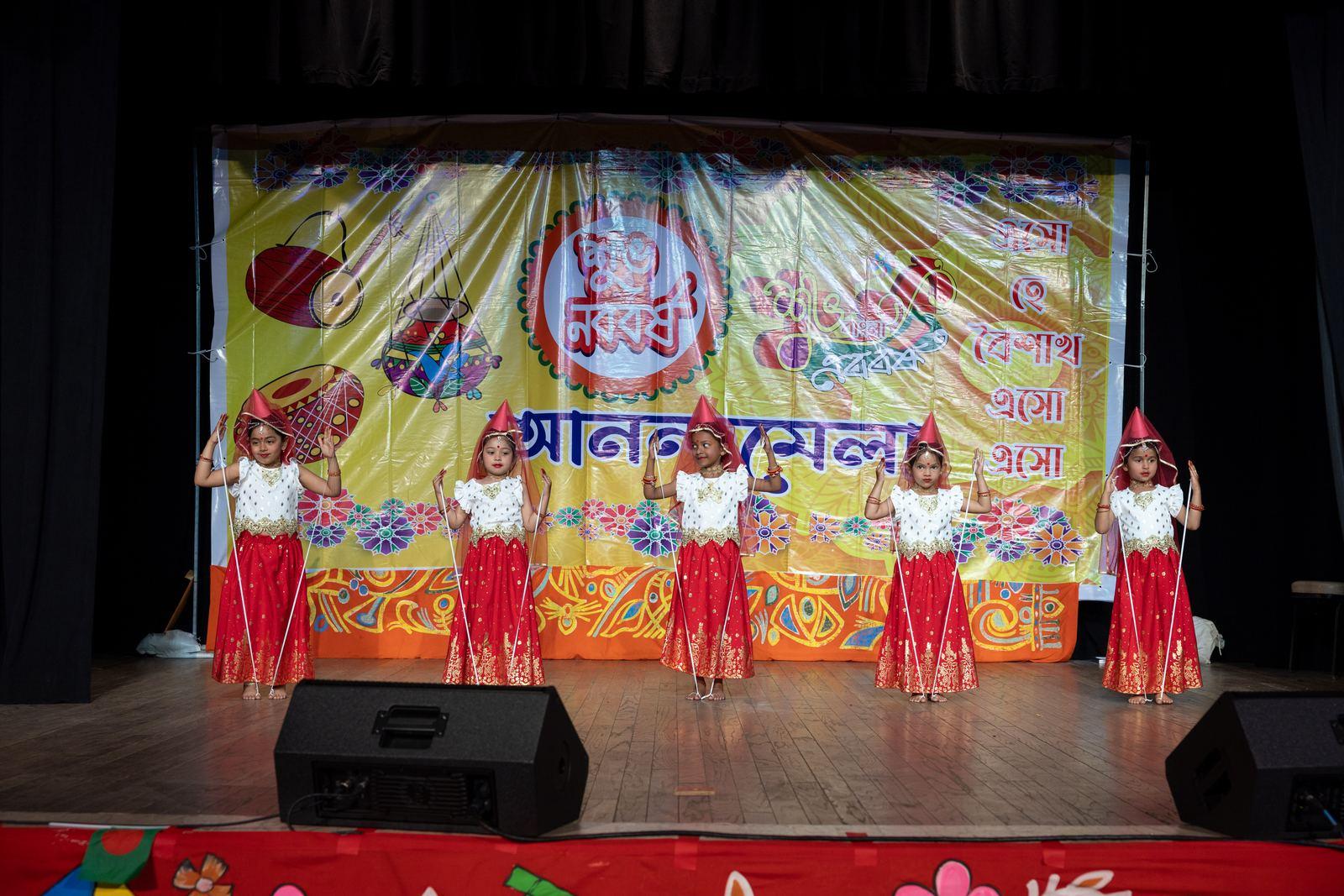 Guests dancing on the hall floor near the vendor stalls