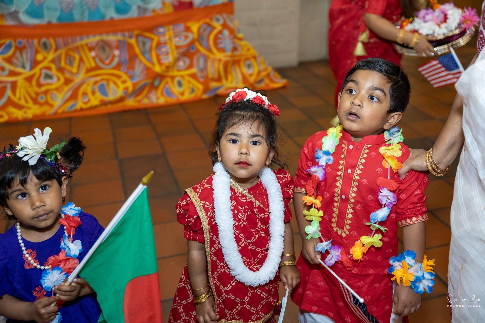 Toddlers and a boy with flags and garlands