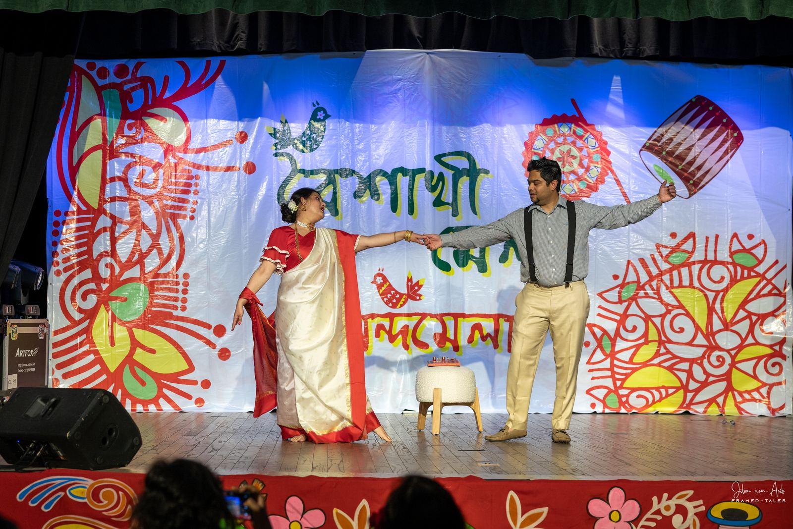 Hosts in a dance-like pose, hands joined
