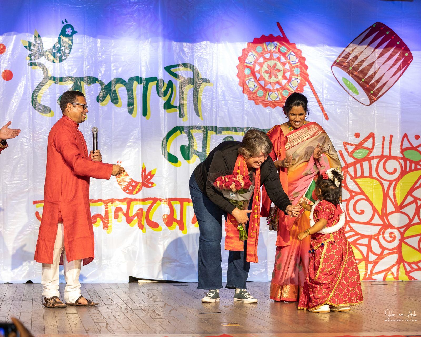 Guest of honor greeting a small child on stage