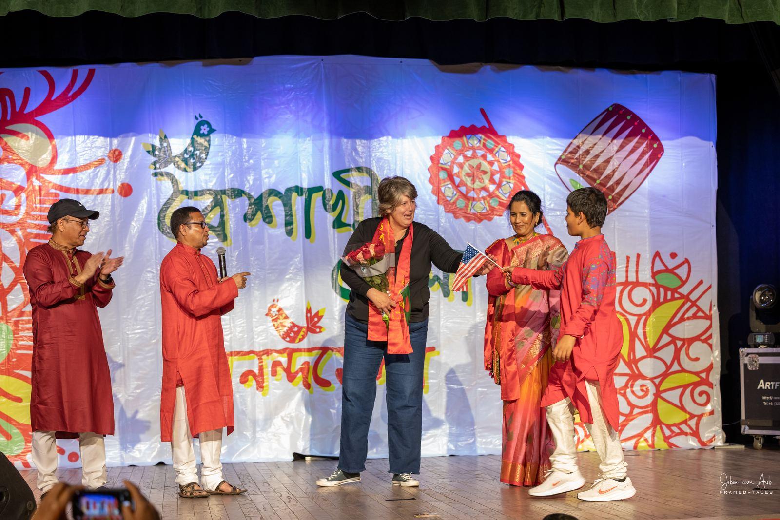 Guest of honor with organizers and a boy, applause