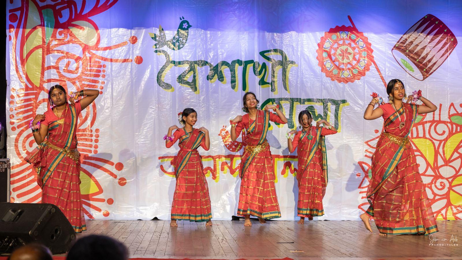 Five dancers in red-check costume, synchronized