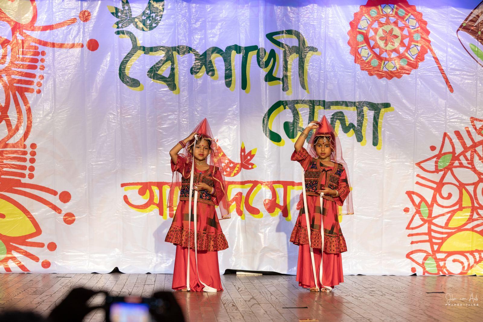 Two girls in hooded red folk costume, pointing
