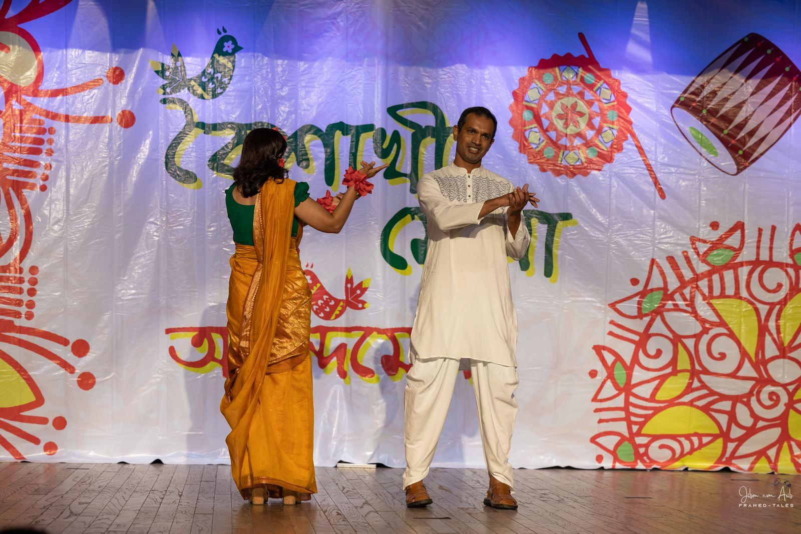 Couple dance, man in white panjabi, woman in yellow saree